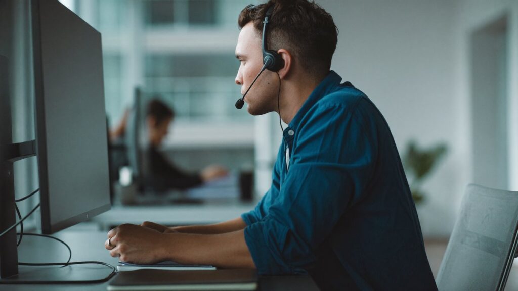 Gestión de quejas ISO 9001: especialista de calidad atendiendo la queja de un cliente con auricular